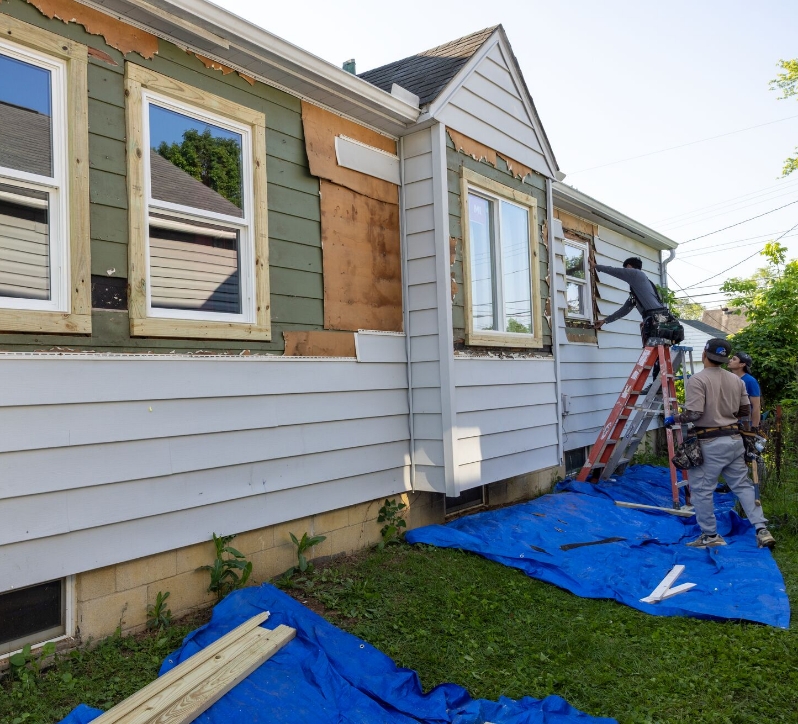three men installing new siding on a house